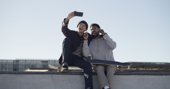 Men, skateboard and friends with selfie on ramp, smile or hug with sky, memory and web post at park. People, embrace and happy skater with photography, low angle and extreme sports on social network