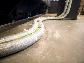 Cables running along the floor in an industrial setting during a maintenance routine