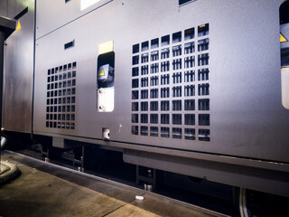 Equipment panel featuring ventilation grilles in a manufacturing facility at night