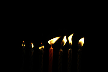 Seven Lit Candles in a Dark Setting Depicting Light and Festivity