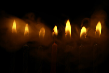 Glowing Candle Flames with Smoky Background in Dark Setting
