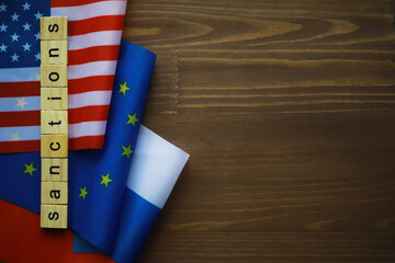 Sanctions Concept with USA, EU, and Russian Flags on Wooden Background