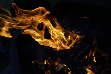 Close-up of Intense Flames on a Charcoal Grill at Night - Abstract Shapes in Fire