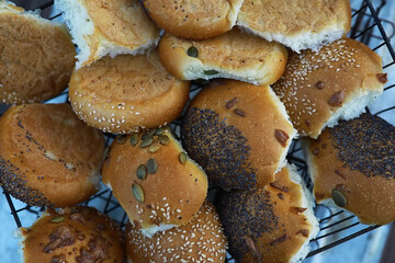 Assorted Fresh Buns in a Basket: Variety of Seeded, Plain, and Poppy Seed Toppings
