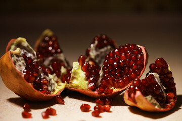 Juicy Pomegranate Seeds Scattered on Rustic Surface in Warm Lighting