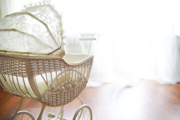 Vintage Wicker Baby Carriage with Lace Canopy in Sunlit Room
