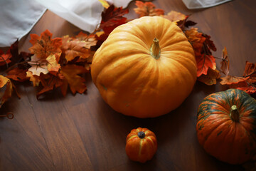 Autumn Harvest: Pumpkins and Fall Leaves on Wooden Table for Seasonal Decor
