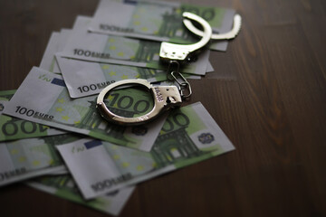 Handcuffs on Euro Currency Notes Depicting Financial Crime and Law Enforcement