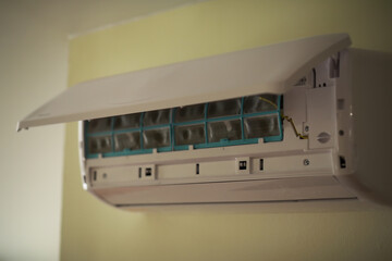 Plakat Modern Wall-Mounted Air Conditioner Unit in Operation with Open Front Panel