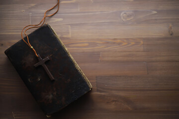 Antique Bible with Wooden Cross on Rustic Wooden Table - Vintage Religious Symbolism