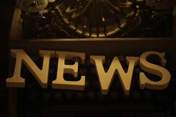 Vintage Typewriter with NEWS Sign in Golden Light - Retro Communication and Journalism Concept