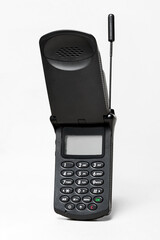 Vintage mobile phone from the 90s featuring extended antenna and open flip cover, isolated on white background