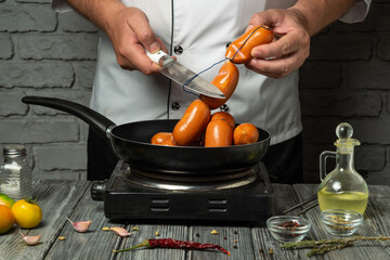 A chef cooks sausages in a skillet, expertly handling the ingredients. Fresh herbs, garlic, and...