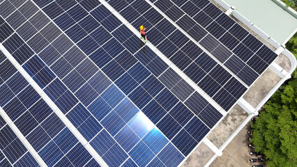 Worker conducts maintenance on solar panels at an industrial facility in daylight