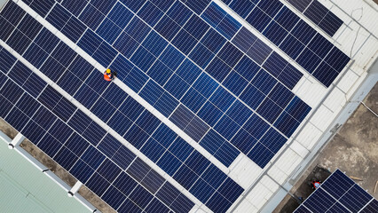 Workers installing solar panels on a rooftop on a sunny day in an urban setting