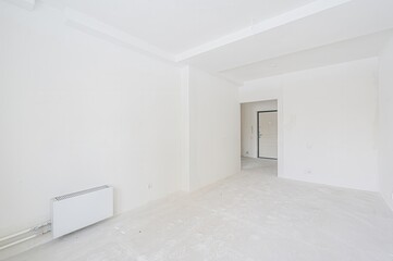 bright, empty room painted entirely white. A door frame is visible