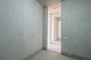 interior shot of a corridor in a building under construction, with concrete walls, floors, and exposed brickwork © evgeniykleymenov
