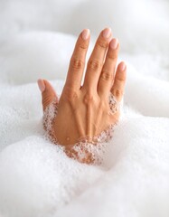 Soft hand submerged in bubbly, foamy water