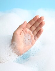 Fototapeta premium Soft hand submerged in bubbly, foamy water