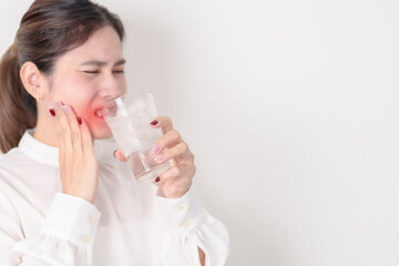Business woman having toothache and pain after drink ice water for concept of Teeth Sensitive to...