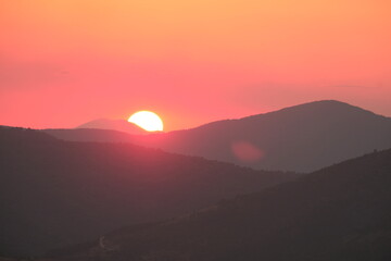 Sun setting behind mountains