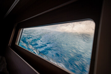 View through the bow cabin window of a sailing yacht leaning into the sea near Croatia. Sailing in strong wind, heeling movement and immersive life on board.