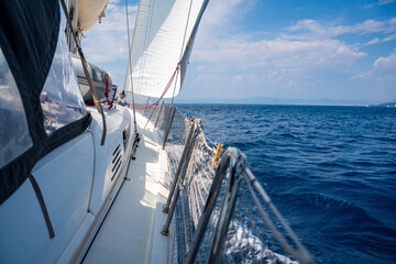 Fototapeta premium Side of a sailing yacht cutting through the sea with full sails near Croatia. Motion, freedom, sailing lifestyle and adventure on the open water.