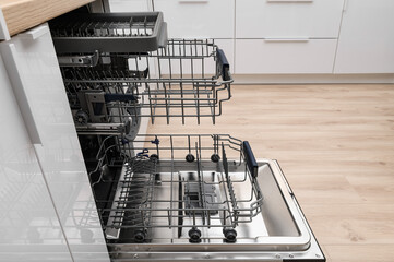 Open electric dishwasher in the kitchen