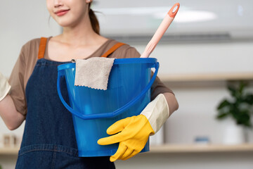 Home Cleaning. Woman with cleaning supplies ready to tidy up indoor space.