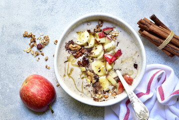 Delicious banana smoothie with apples, nuts and honey in a bowl. Top view with copy space.