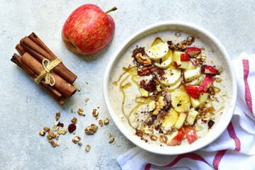 Delicious banana smoothie with apples, nuts and honey in a bowl. Top view with copy space.