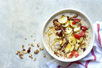 Delicious banana smoothie with apples, nuts and honey in a bowl. Top view with copy space.