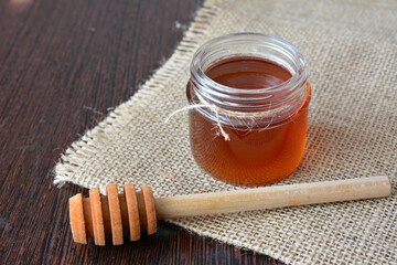 buckwheat honey in a Jar and Dipper on Burlap tablecloth
