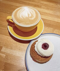 A cup of cappuccino and a plate of meringue pie