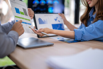 A woman is holding a pen and pointing at a graph on a table