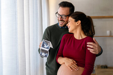 Man in love hugs his pregnant wife, they are waiting together for the baby's arrival. Love, family