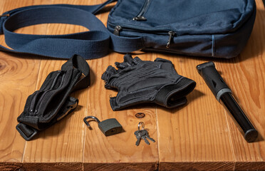 Outdoors and cycling stuff on a wooden table. Waist bend, lock, key, cycling gloves, pump and a...