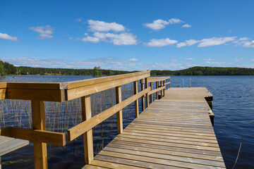 Obraz premium Perspective view of a wooden pier. Summer vacation on the lake shore in Finland