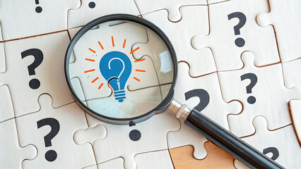 Jigsaw puzzle shows magnifying glass, lightbulb idea, question marks. Concept for problem-solving, education, and branding.