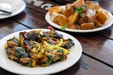 Supra, a Georgian feast, featuring eggplant salad and fried potatoes on a rustic table