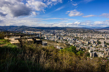 A high-angle captures Tbilisi, from Sololaki's wooden structure. The city, a mix of old and new,...