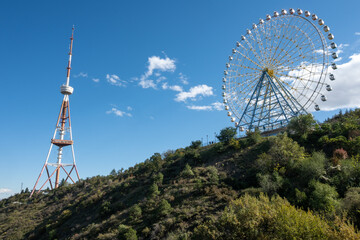 Urban landmark featuring Tbilisi TV tower, built in 1955, and Mtatsminda Ferris wheel, a modern...