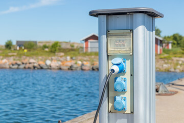 Charging station for boats at a marina pier in Finland, with electrical outlets where sailboats and...