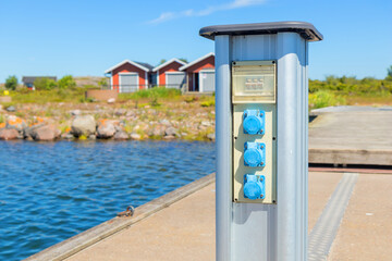 Charging station for boats at a marina pier in Finland, with electrical outlets for powering...