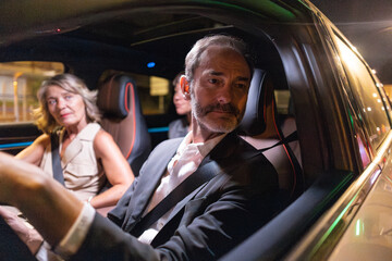 Business people sharing ride in autonomous car at night