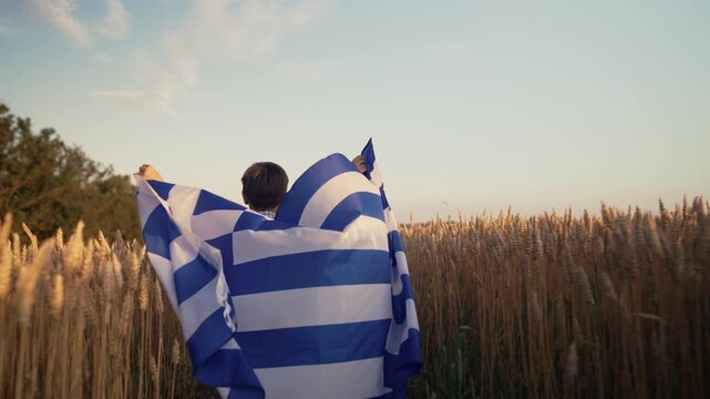 Patriot Boy Running Wheat Field Holding Greek Hellas Flag in the Wind, Homeland