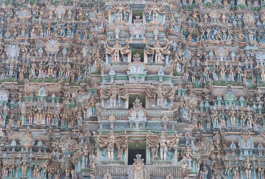 The Meenakshi Amman Temple,  a historic Hindu temple located in Madurai, Tamilnadu, India, its gopurams or gateway towers adorned with intricate carvings of mythological figures.