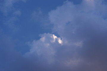 High Saturation Blue Evening Sky with Sunlit White Cloud Behind Shadows