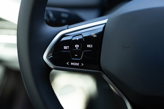 Cruise control buttons, speed limitation, car's signal. Close up of steering wheel of a new electric vehicle. Electric car control devices