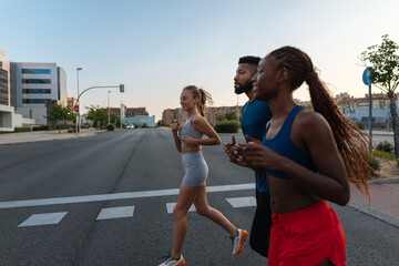 Fitness friends running in the city during sunset